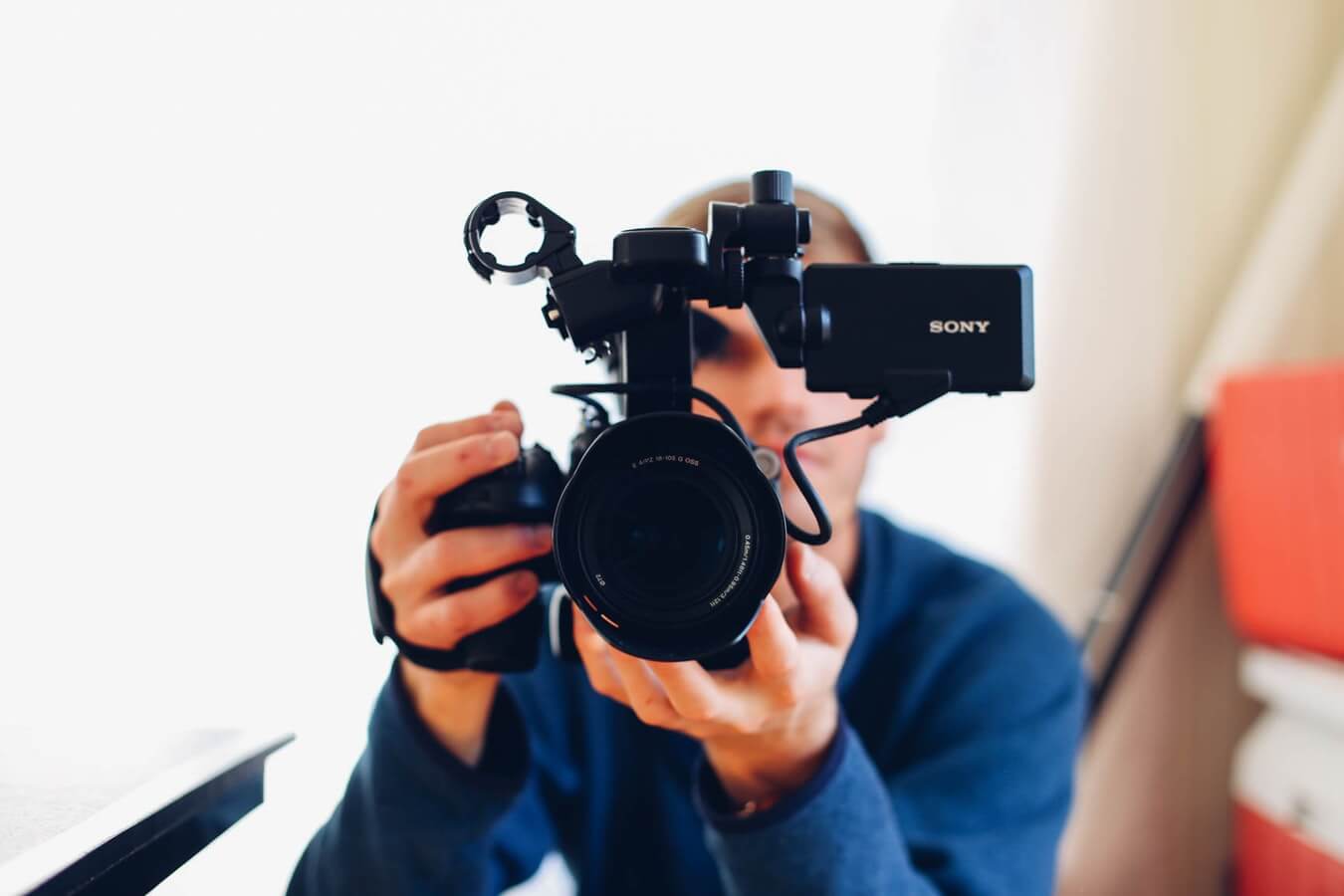 man holding camera, filming a video